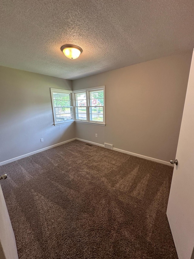 332 Pleasant Ave, Ellsworth, WI 54011 - unfurnished room featuring dark colored carpet, a textured ceiling, and baseboards