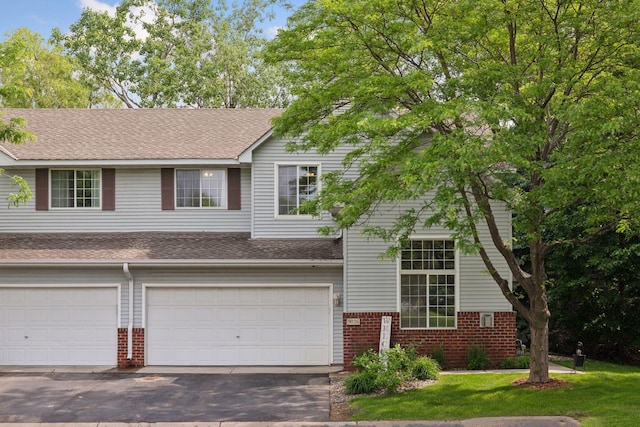 9026 Merrimac Ln N, Maple Grove, MN 55311 - view of front of home featuring brick siding, a shingled roof, an attached garage, and asphalt driveway