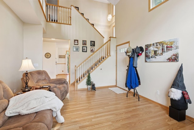 9026 Merrimac Ln N, Maple Grove, MN 55311 - living area with stairs, wood finished floors, a towering ceiling, and baseboards