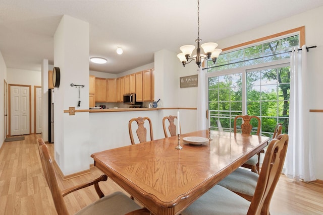 9026 Merrimac Ln N, Maple Grove, MN 55311 - dining room featuring a chandelier, light wood-style floors, and baseboards