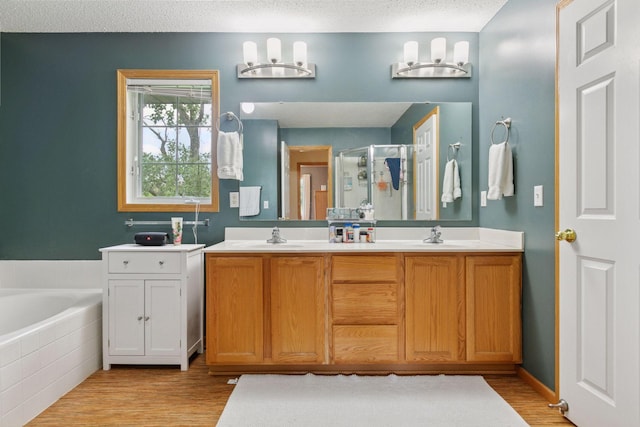 9026 Merrimac Ln N, Maple Grove, MN 55311 - full bath with a stall shower, wood finished floors, double vanity, a garden tub, and a textured ceiling