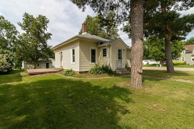 717 2nd Ave NE, Waseca, MN 56093 - view of front facade featuring a chimney, a front yard, and a wooden deck