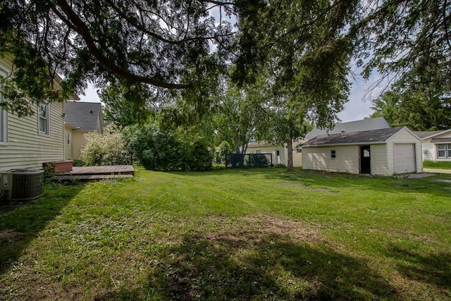 717 2nd Ave NE, Waseca, MN 56093 - view of yard featuring central AC, a wooden deck, an outbuilding, and a garage