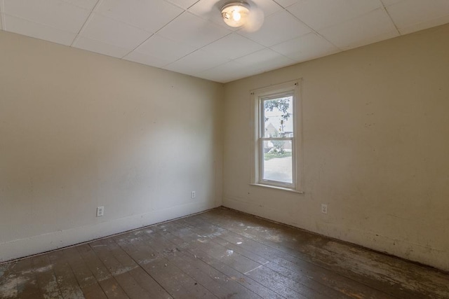 717 2nd Ave NE, Waseca, MN 56093 - unfurnished room with wood-type flooring, a paneled ceiling, and baseboards