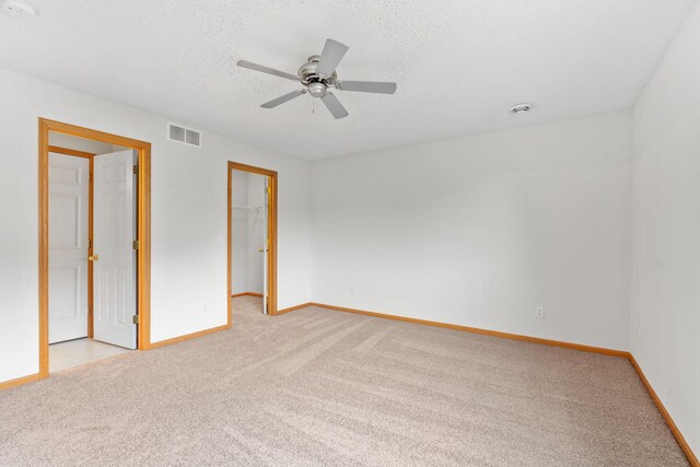 5423 Elm Grove Ave, New Hope, MN 55428 - unfurnished bedroom featuring light carpet, a walk in closet, ceiling fan, a textured ceiling, and a closet