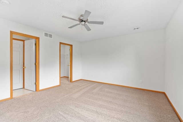 5423 Elm Grove Ave, New Hope, MN 55428 - unfurnished bedroom featuring light carpet, a walk in closet, ceiling fan, a textured ceiling, and a closet