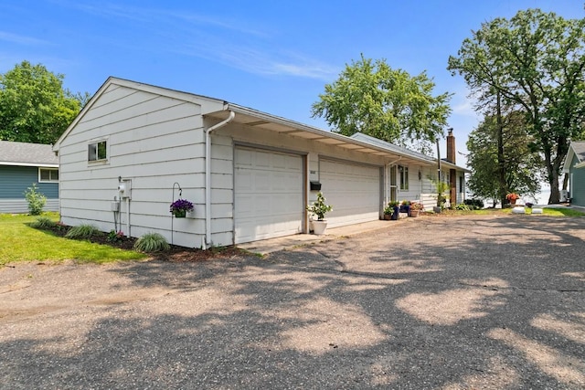 6567 Shore Trl N, Forest Lake, MN 55025 - view of property exterior with a chimney and a garage