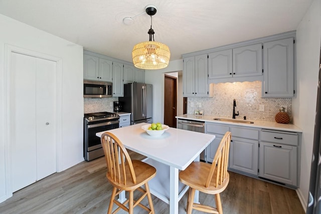 6567 Shore Trl N, Forest Lake, MN 55025 - kitchen featuring appliances with stainless steel finishes, backsplash, wood finished floors, and a chandelier