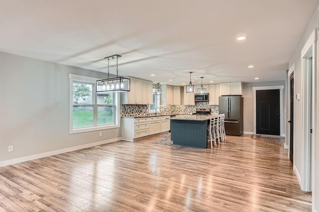 2865 Pilot Knob Rd, Eagan, MN 55121 - kitchen featuring stainless steel appliances, a kitchen island, backsplash, a breakfast bar area, and recessed lighting