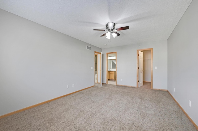 17790 66th Ave N, Maple Grove, MN 55311 - unfurnished bedroom featuring a walk in closet, light colored carpet, a textured ceiling, ensuite bath, and a ceiling fan