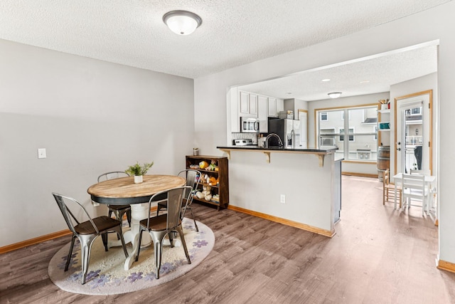 15040 Farnham Ave N, Hugo, MN 55038 - dining space with light wood-style floors and a textured ceiling