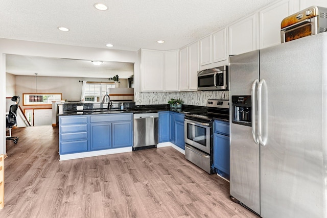 15040 Farnham Ave N, Hugo, MN 55038 - kitchen with appliances with stainless steel finishes, blue cabinets, dark countertops, white cabinets, and light wood finished floors