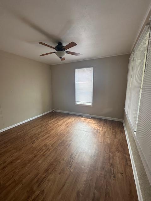 2014 Oakland Ave, Austin, MN 55912 - unfurnished room with dark wood-type flooring, a ceiling fan, and baseboards