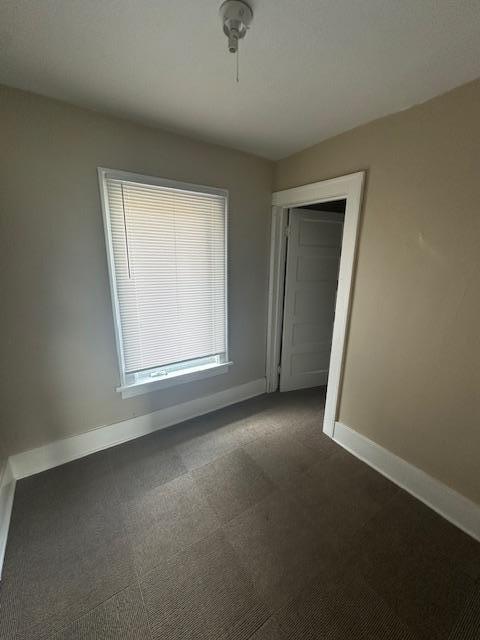 2014 Oakland Ave, Austin, MN 55912 - spare room featuring baseboards and dark colored carpet