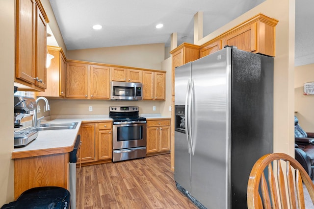 3168 Molina St, Shakopee, MN 55379 - kitchen with stainless steel appliances, light wood-style flooring, light countertops, vaulted ceiling, and recessed lighting