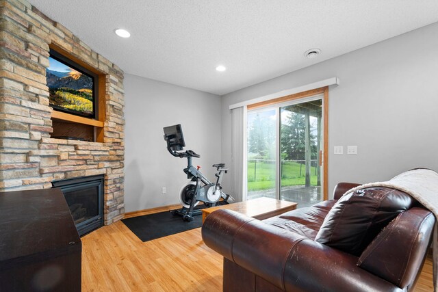 3168 Molina St, Shakopee, MN 55379 - living area featuring wood finished floors, a fireplace, recessed lighting, and a textured ceiling