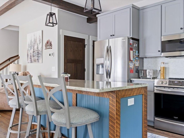 12144 Sylvan Dr SW, Sylvan Twp, MN 56473 - kitchen with stainless steel appliances, wood finished floors, a kitchen bar, and pendant lighting