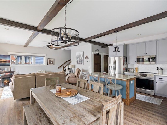 12144 Sylvan Dr SW, Sylvan Twp, MN 56473 - dining space featuring beam ceiling, light wood finished floors, a chandelier, and ceiling fan