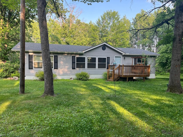 23324 State Highway 107, Grasston, MN 55030 - view of front of property with a wooden deck, a front lawn, and roof with shingles