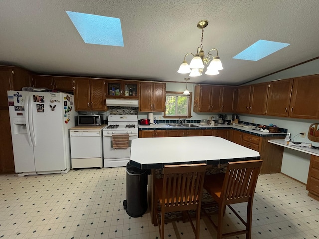 23324 State Highway 107, Grasston, MN 55030 - kitchen featuring white appliances, under cabinet range hood, light floors, a skylight, and vaulted ceiling