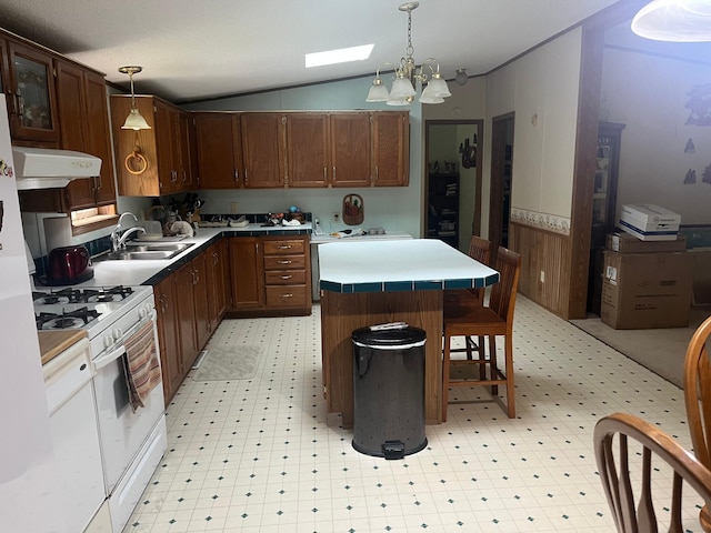 23324 State Highway 107, Grasston, MN 55030 - kitchen with light floors, white range with gas stovetop, range hood, vaulted ceiling, and a kitchen island