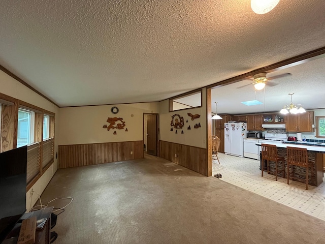 23324 State Highway 107, Grasston, MN 55030 - unfurnished living room with a textured ceiling, wainscoting, lofted ceiling, wood walls, and a chandelier