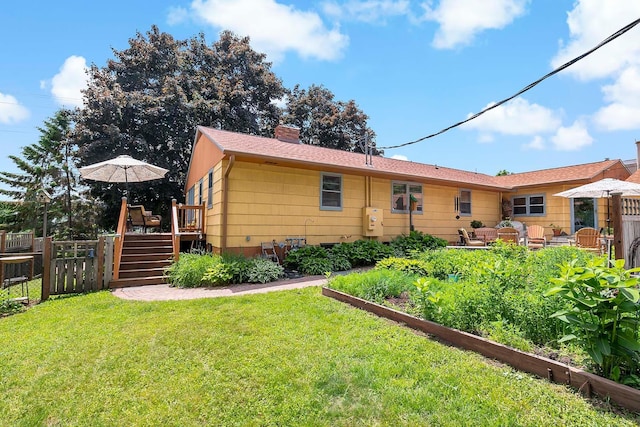 895 Front, Saint Paul, MN 55103 - back of property featuring a deck, a chimney, stairs, and a vegetable garden