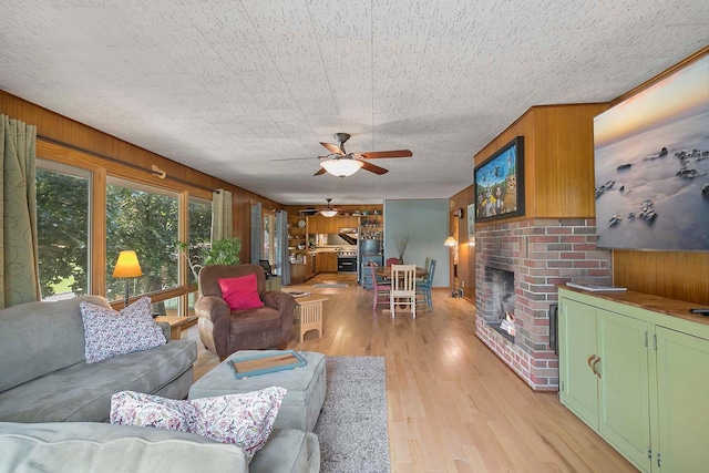 895 Front, Saint Paul, MN 55103 - living room featuring a ceiling fan, wood walls, light wood-style floors, and a fireplace