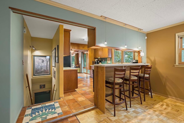 895 Front, Saint Paul, MN 55103 - kitchen featuring brown cabinetry, light countertops, a breakfast bar area, and a peninsula