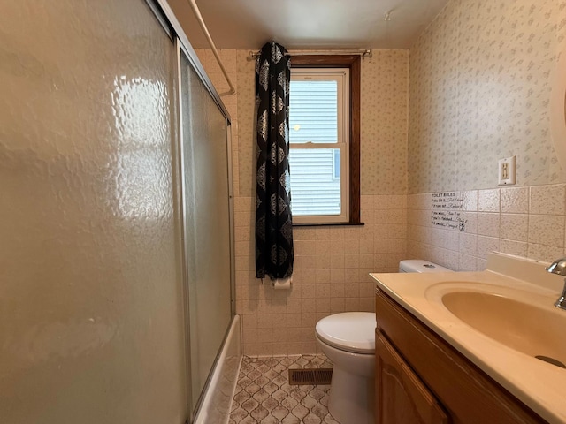 845 Sims Ave, Saint Paul, MN 55106 - bathroom featuring tile patterned flooring, toilet, tile walls, vanity, and wainscoting