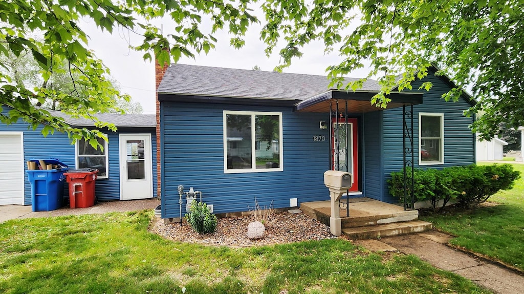 1870 4th St, Winona, MN 55987 - view of front of house featuring a front lawn, roof with shingles, and a chimney