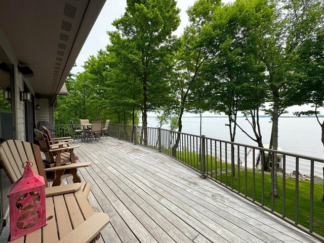 2438 Birch Point Rd, Greenwood Twp, MN 55790 - wooden deck with outdoor dining area and a water view