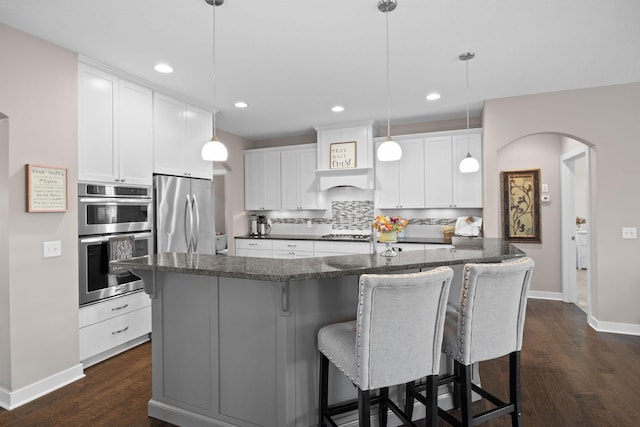 3710 Talero Curv, Chaska, MN 55318 - kitchen featuring appliances with stainless steel finishes, baseboards, dark wood-style floors, a breakfast bar area, and recessed lighting