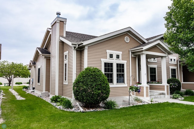 1365 Highpointe Dr N, Fargo, ND 58102 - view of front of home with a front yard, a chimney, and a shingled roof