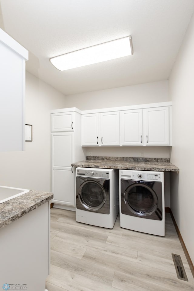 1365 Highpointe Dr N, Fargo, ND 58102 - washroom with separate washer and dryer, cabinet space, and light wood finished floors