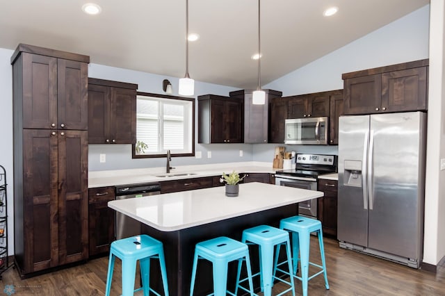 6675 57th Ave S, Fargo, ND 58104 - kitchen featuring appliances with stainless steel finishes, vaulted ceiling, dark brown cabinets, a breakfast bar area, and dark wood finished floors