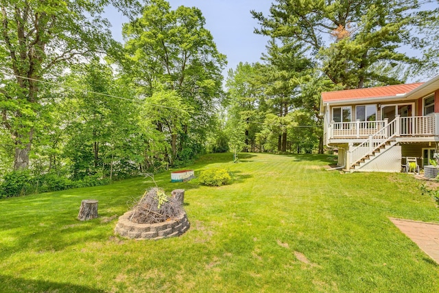 10275 Park Cir, Pine City, MN 55063 - view of grassy yard featuring an outdoor fire pit, a sunroom, and stairs