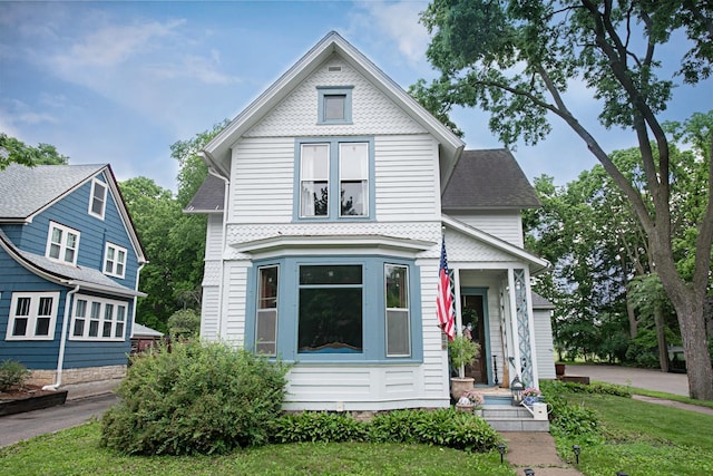 72 Mill St, Winona, MN 55987 - victorian-style house featuring a front lawn and a shingled roof