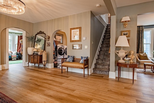 72 Mill St, Winona, MN 55987 - living area with washer and dryer, arched walkways, stairs, and light wood-style flooring