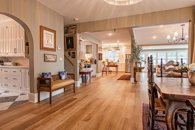 72 Mill St, Winona, MN 55987 - dining area featuring a chandelier, arched walkways, light wood finished floors, recessed lighting, and baseboards