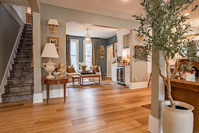 72 Mill St, Winona, MN 55987 - living area with beverage cooler, stairway, light wood-type flooring, and baseboards