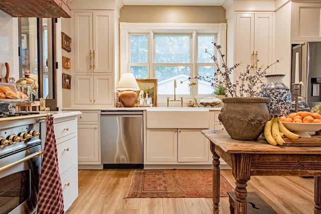 72 Mill St, Winona, MN 55987 - kitchen with stainless steel appliances, light wood-style floors, a sink, light countertops, and white cabinets