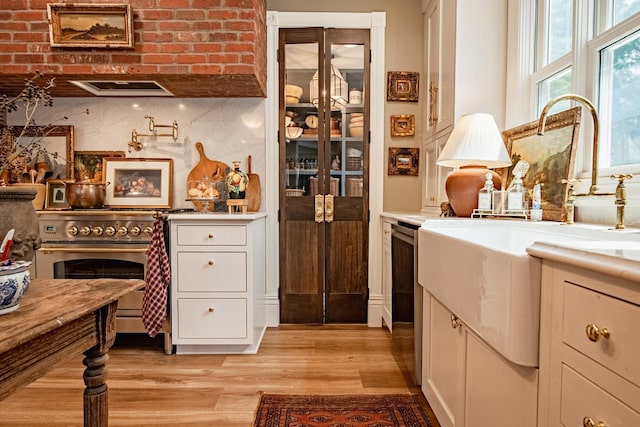 72 Mill St, Winona, MN 55987 - kitchen featuring stainless steel appliances, light wood finished floors, a sink, and white cabinets