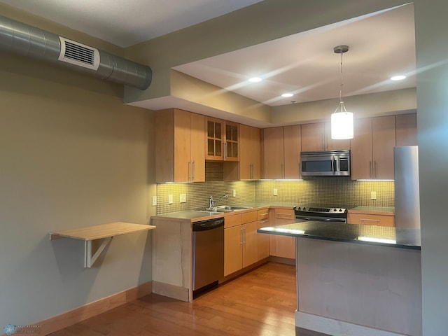 319 Broadway N Unit 207, Fargo, ND 58102 - kitchen featuring stainless steel appliances, light wood-style floors, recessed lighting, tasteful backsplash, and a sink