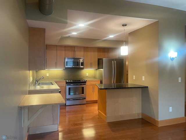 319 Broadway N Unit 207, Fargo, ND 58102 - kitchen featuring appliances with stainless steel finishes, a peninsula, tasteful backsplash, light wood-style flooring, and recessed lighting