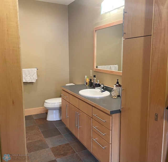 319 Broadway N Unit 207, Fargo, ND 58102 - bathroom with vanity, toilet, stone finish flooring, and baseboards