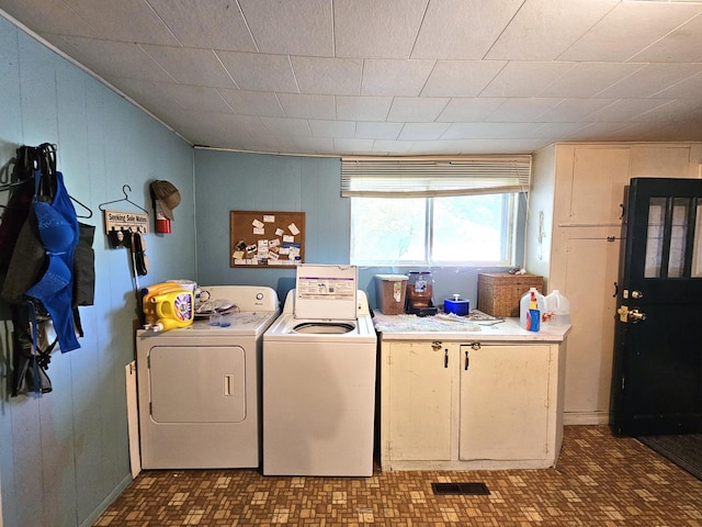 214 Vasa Ave, Fergus Falls, MN 56537 - washroom featuring cabinet space, washing machine and dryer, and wood walls