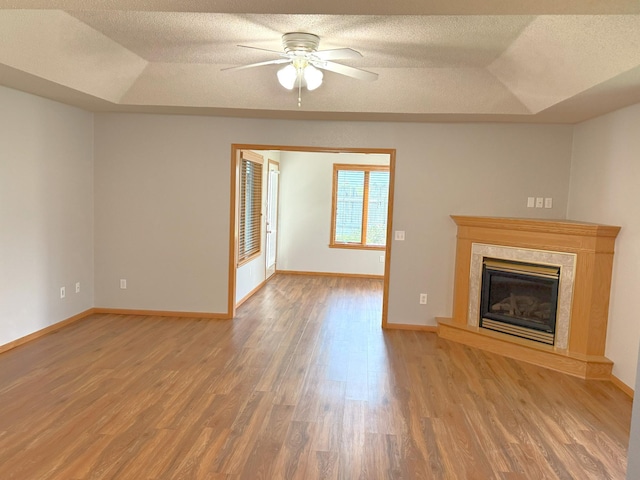 1423 Fairview Ln, Little Falls, MN 56345 - unfurnished living room with a raised ceiling, wood finished floors, a high end fireplace, ceiling fan, and a textured ceiling