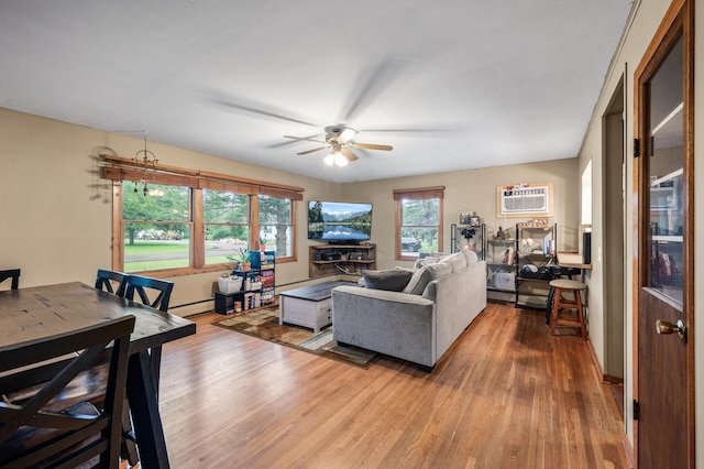 677 Quinnell Ave N, Lakeland, MN 55043 - living area featuring wood finished floors, a ceiling fan, a baseboard heating unit, and a wall mounted air conditioner