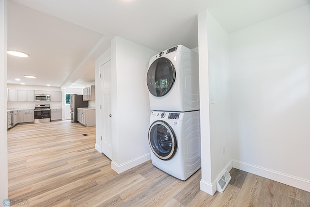 1814 5th St N, Fargo, ND 58102 - washroom featuring estacked washer and dryer, baseboards, light wood-style floors, and recessed lighting